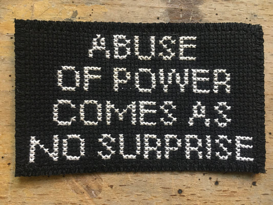 Hand-embroidered patch - Abuse of power comes as no surprise