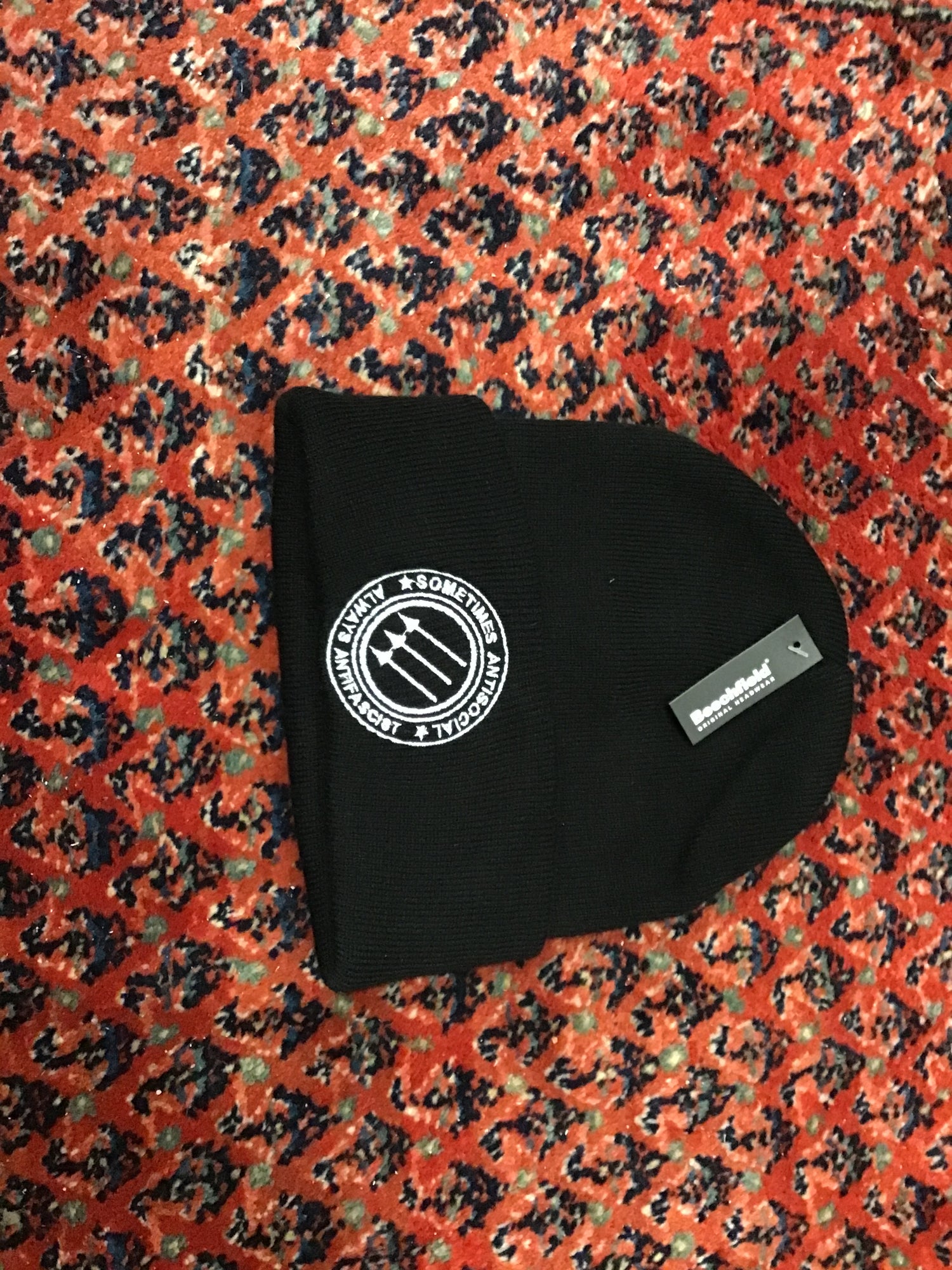 Anti-fascist symbol on a black beanie. Subtitled Sometimes antisocial, always antifascist